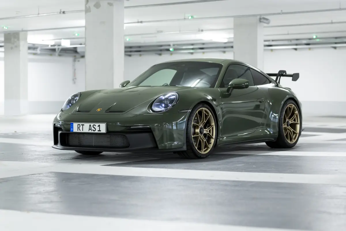 Olivgrüner Porsche 911 GT3 Touring von schräg vorne im Studio der AS Handel GmbH